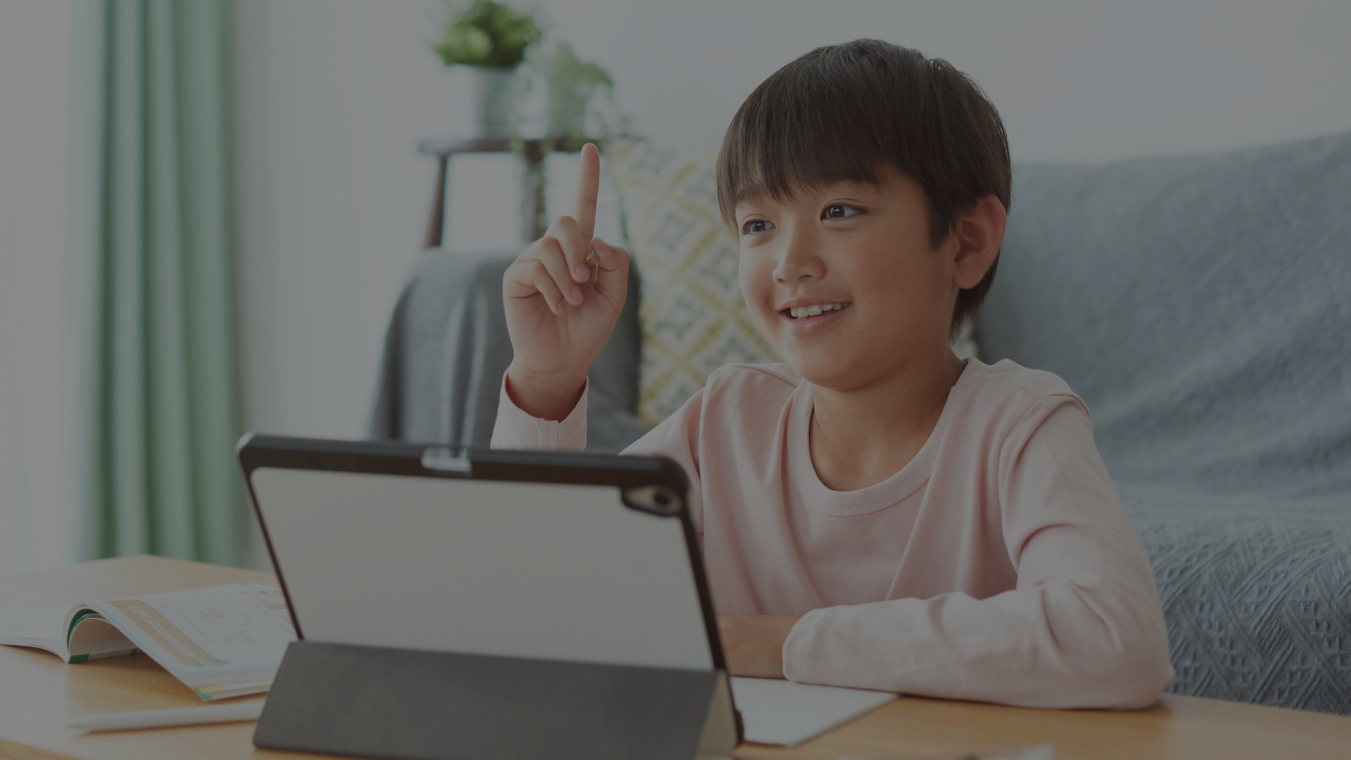 Online elementary school student learning from Wellspring Young girl with headphones smiling during online elementary school class